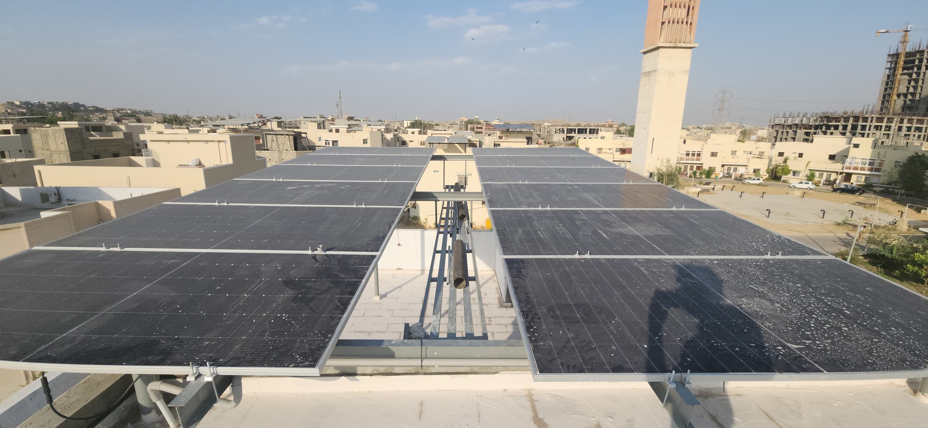 Completed rooftop solar array above a residential neighborhood in Karachi.